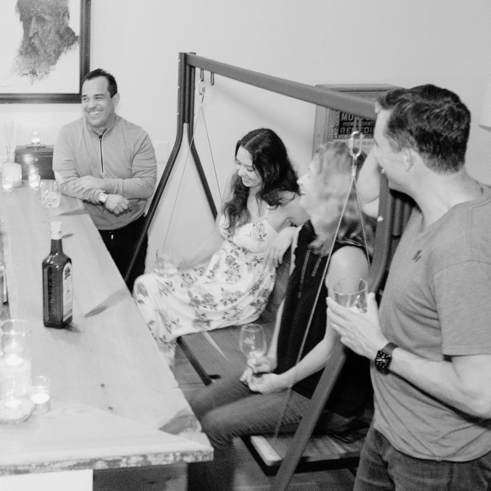 A group of freinds having drinks on a modern wooden indoor swing