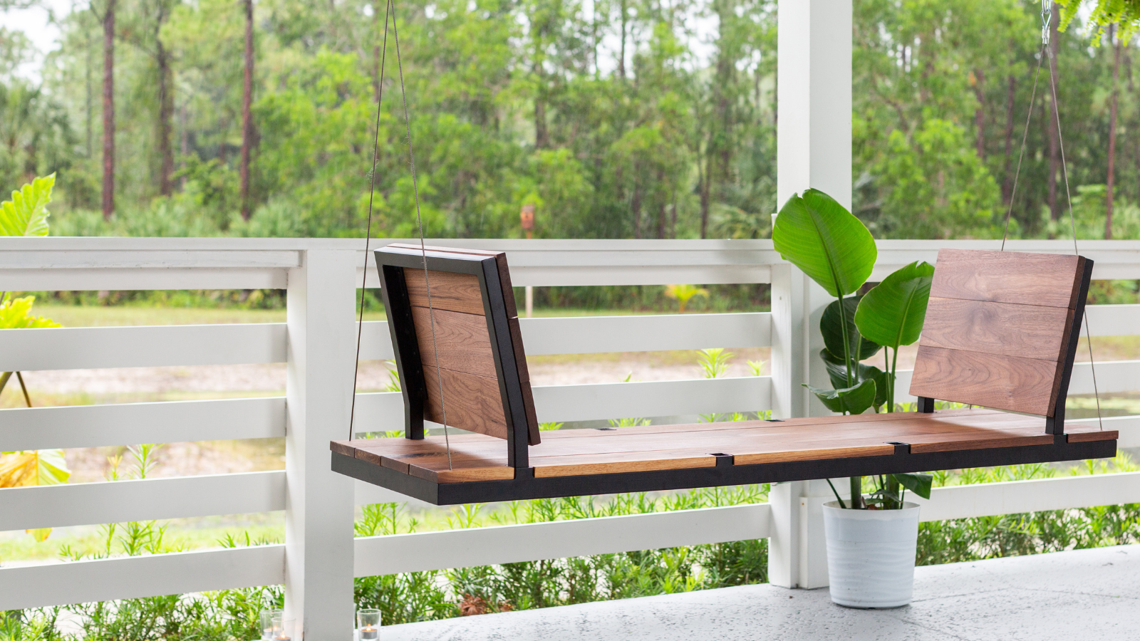 A modern porch swing with the seats facing eachother