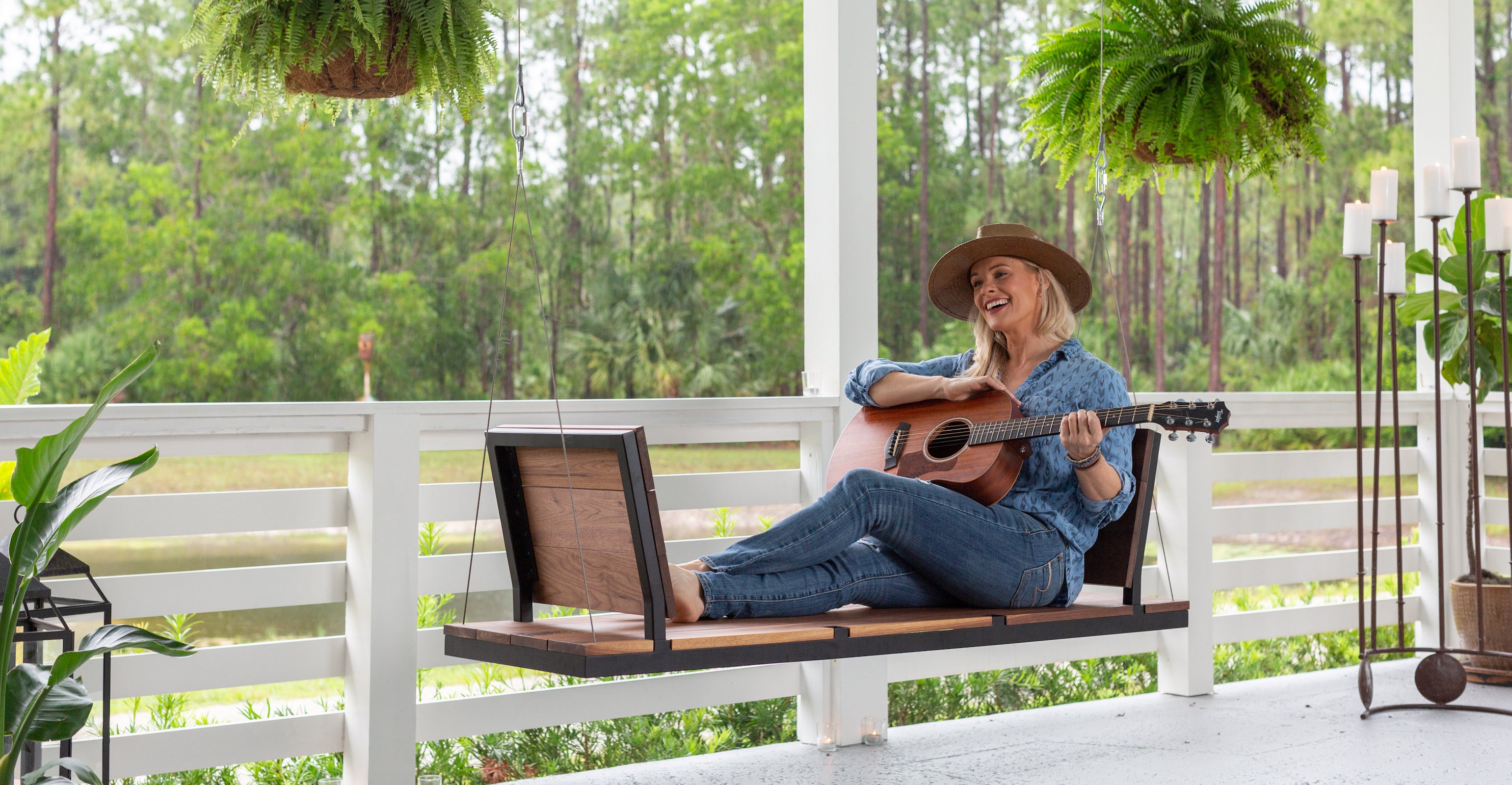 A person playing guitar on a modern porch swing